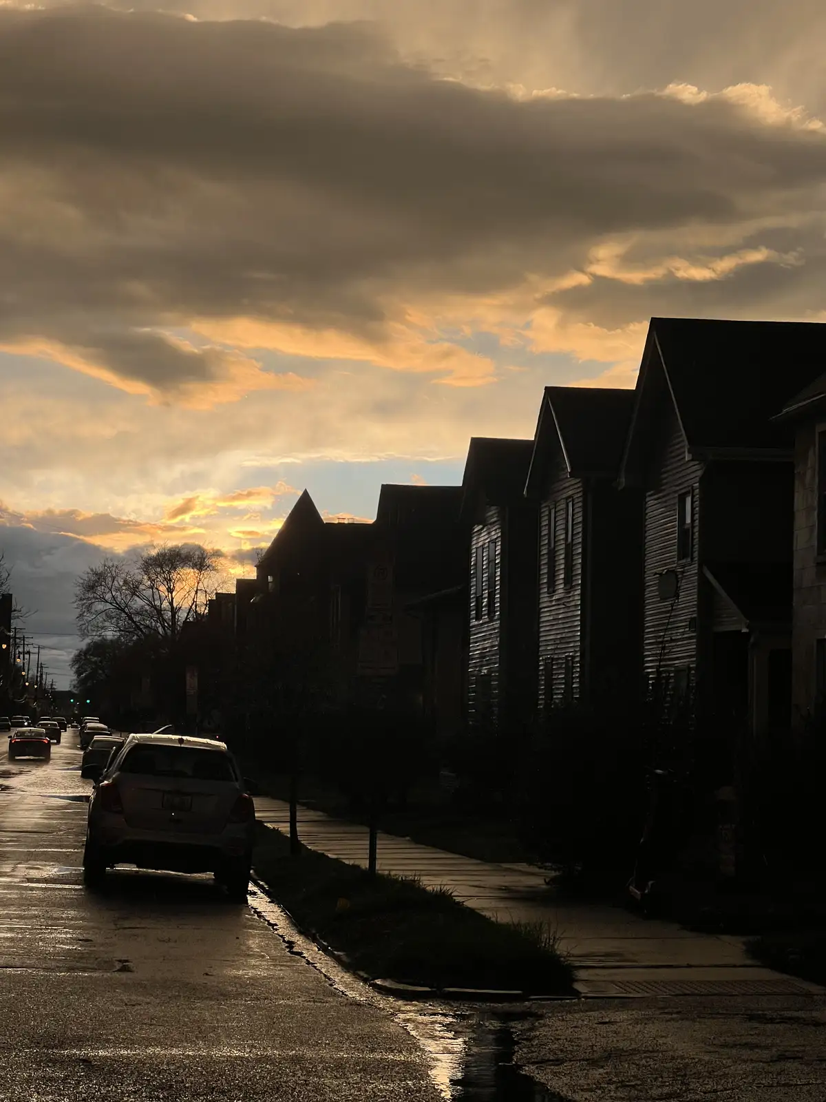 Twilight paints dramatic clouds above a wet, reflective street. Still Frame