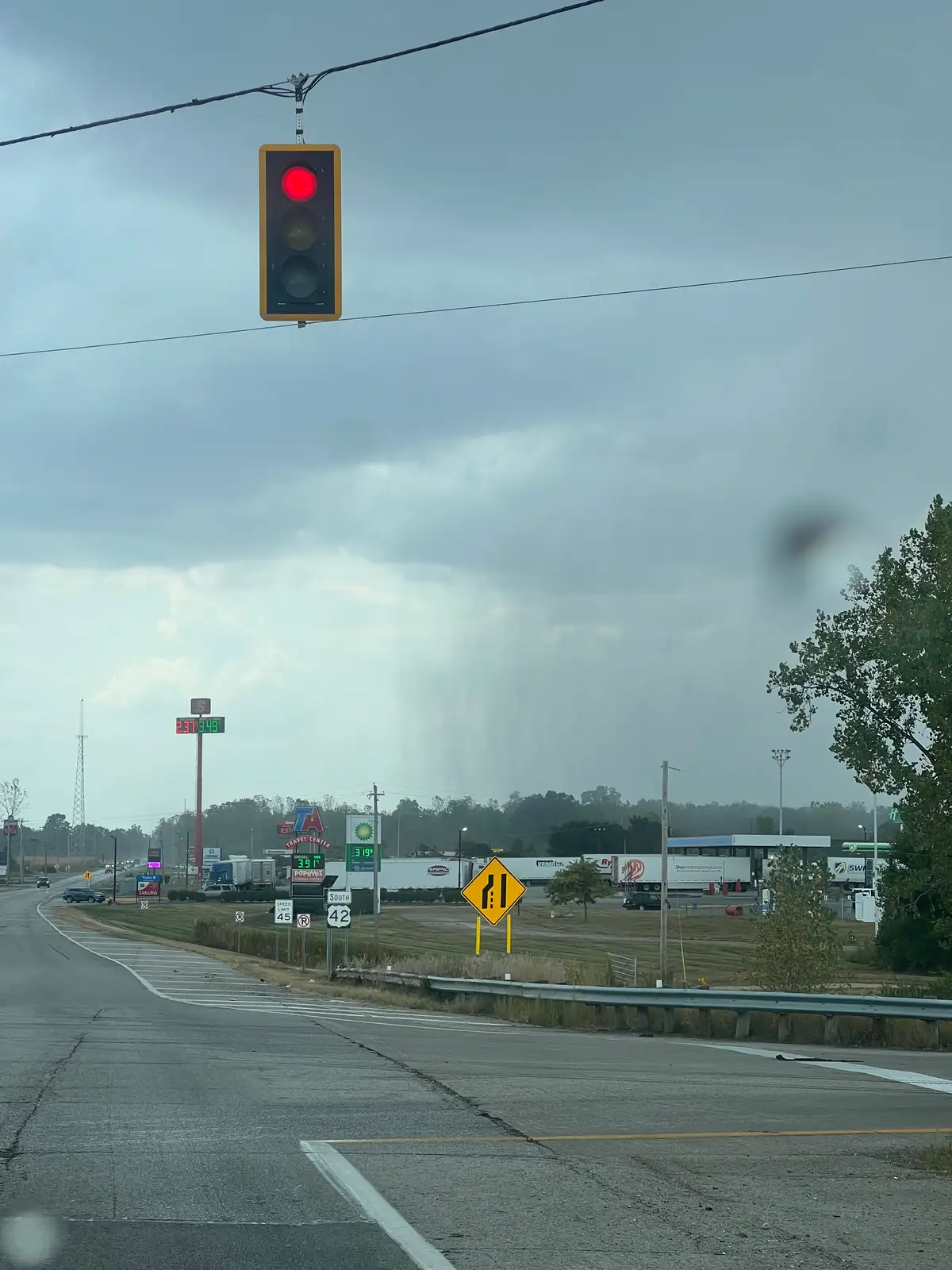Red light, gray sky, and a shower in the distance. Still Frame